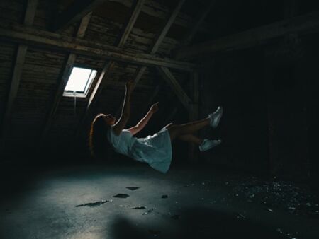 Fall aus dem Glaubenssatz - Momentaufnahme einer fallenden Frau in einem dunklen Raum