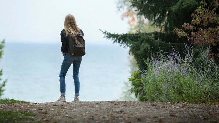 Reise zu deinen Glaubenssätzen - Abbildung einer Frau mit Rucksack am Meer