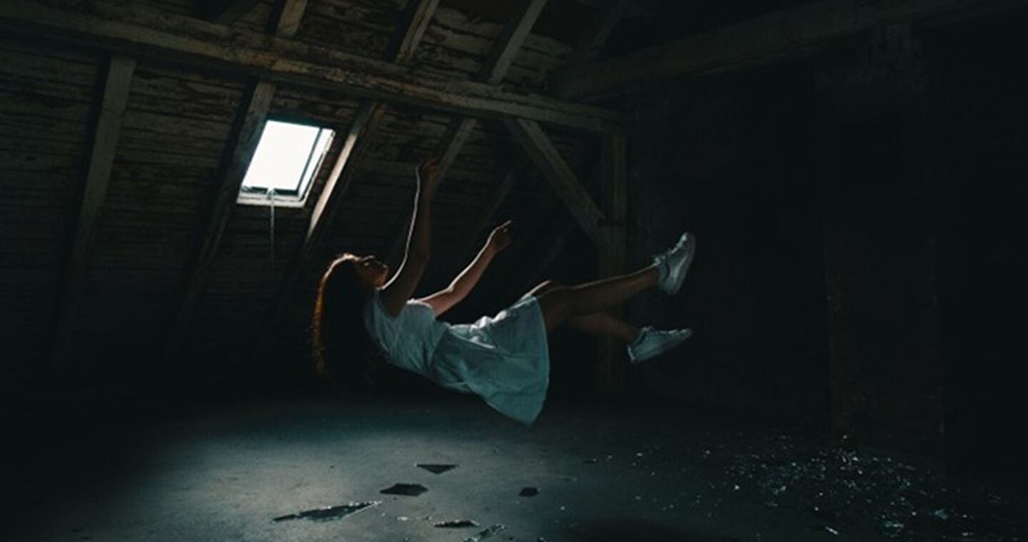 Fall aus dem Glaubenssatz - Momentaufnahme einer fallenden Frau in einem dunklen Raum