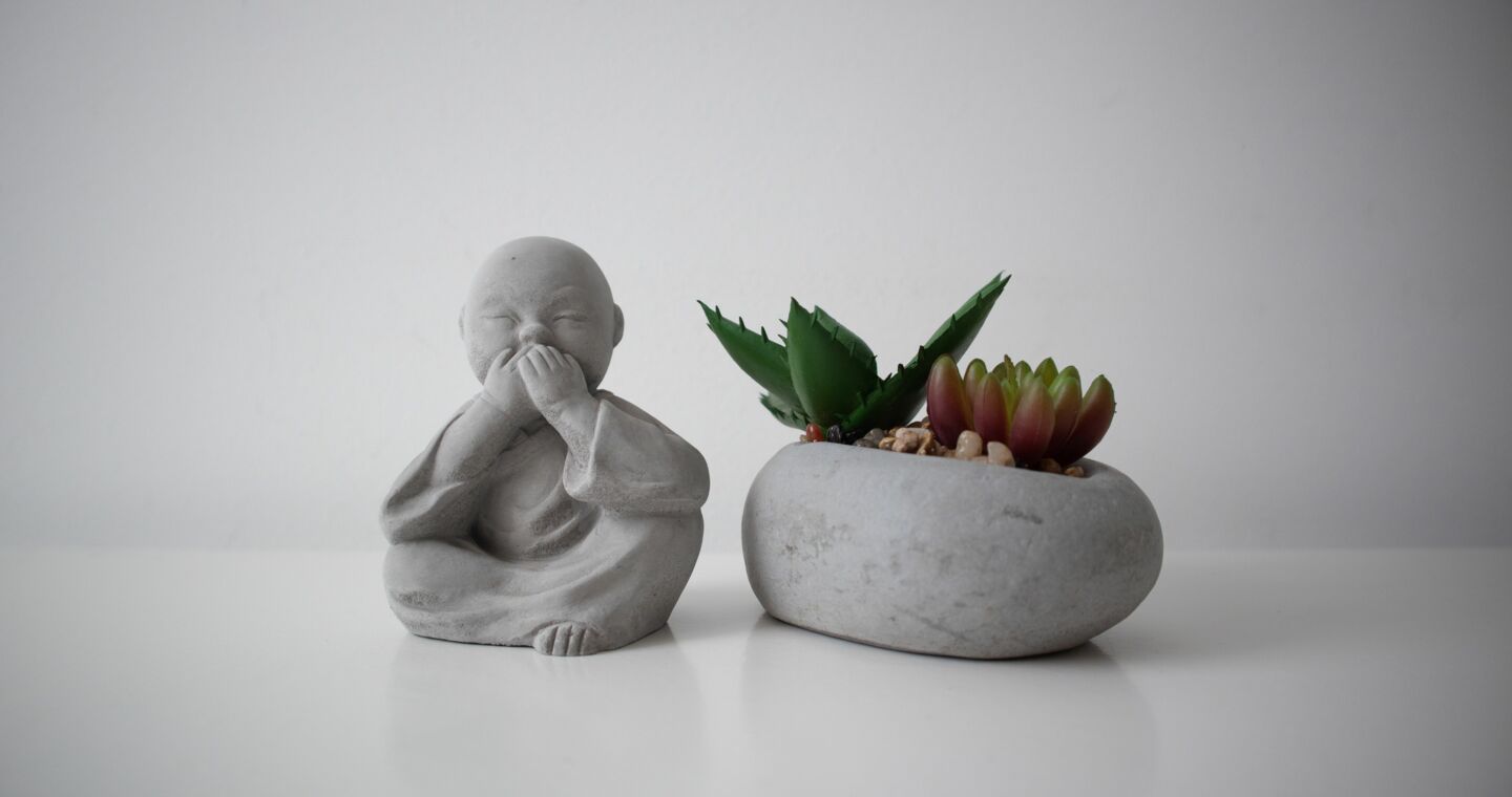 Ein kleiner buddhistischer Mönch neben einem Miniatur-Garten